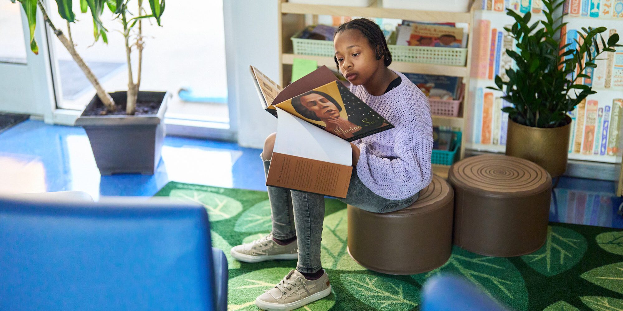 An image of a young student reading independently in the elementary school Book Nook.