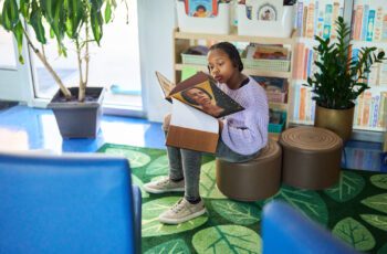 An image of a young student reading independently in the elementary school Book Nook.