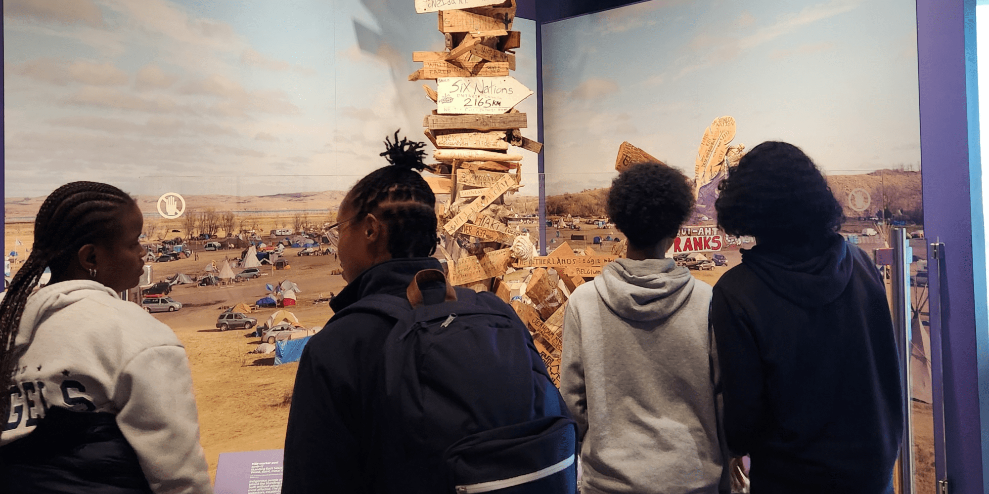 A group of students look at an exhibit.